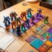 Jeu de société geek prêt à jouer, avec des pions colorés, des tuiles géométriques, des cartes vierges et un petit sablier sur une table.