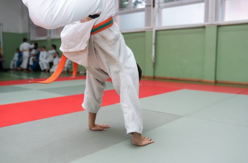 Deux judokas s’entraînent à exécuter une prise de judo sur un tatami.